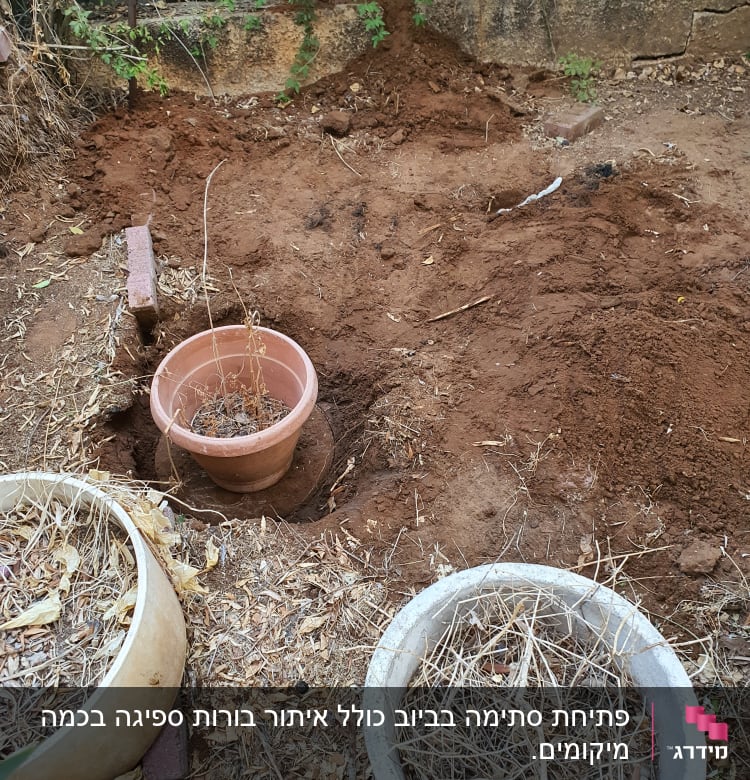 אדמה חפורה עם צינור לבן חשוף בגינה